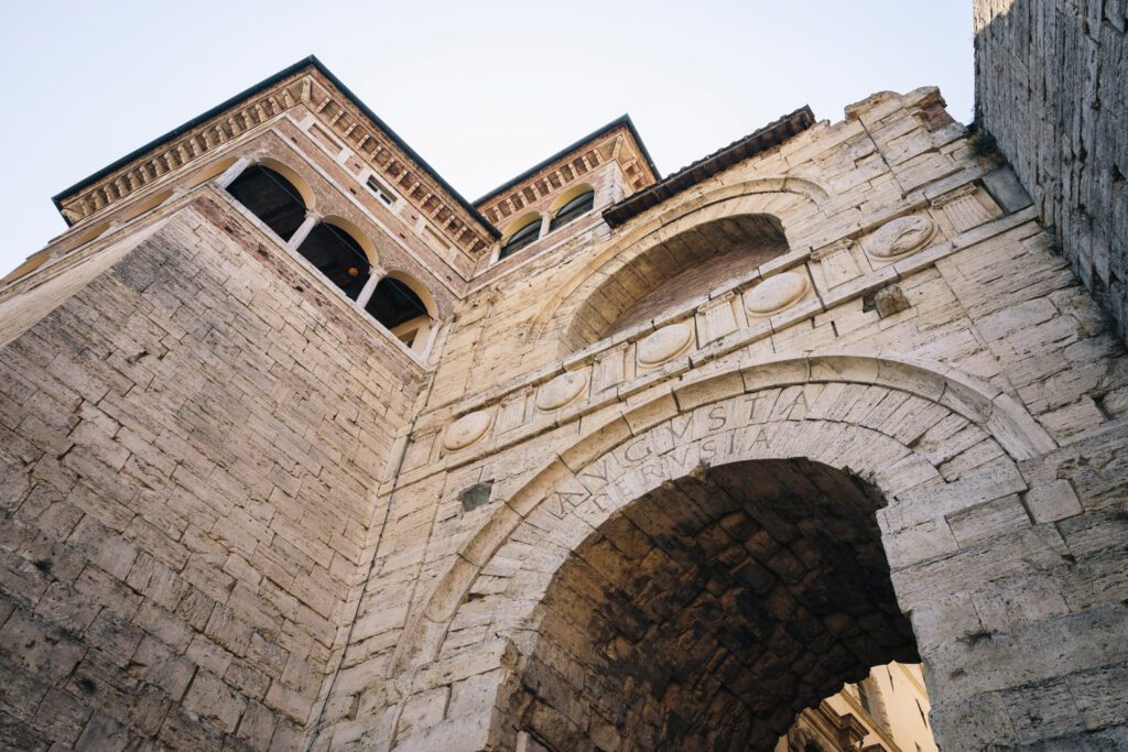 Vista dell'arco etrusco dal basso. In particolare è visibile il dettaglio dell'incisione Augusta Perusia che segue l'andamento semicircolare della sommità dell'arco.