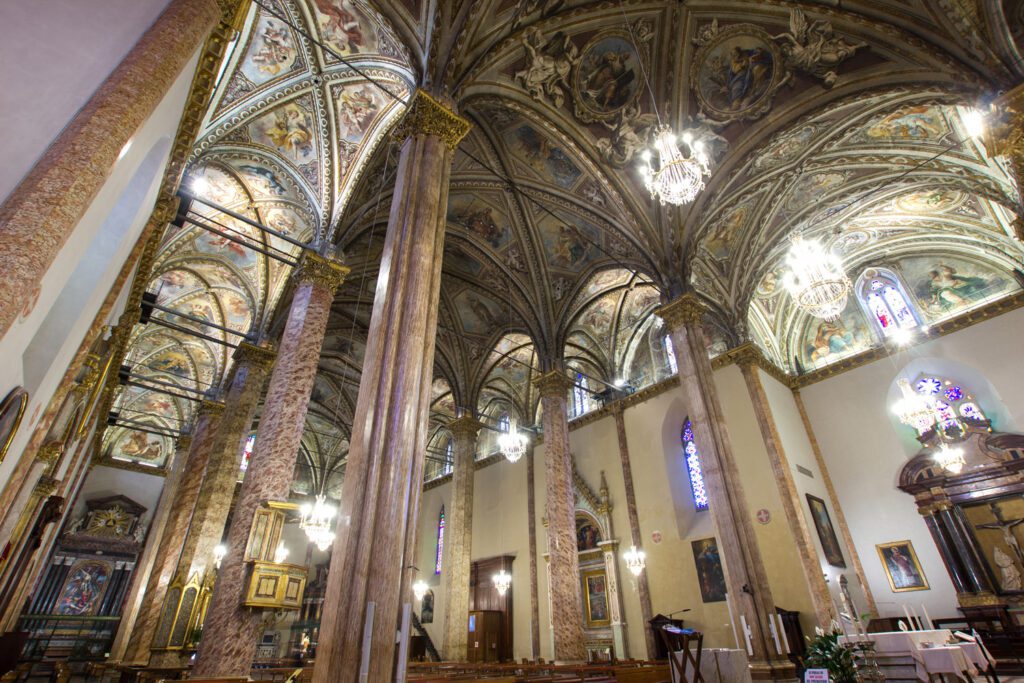 Vista dal basso con grandangolo della Cattedrale di San Lorenzo a Perugia. Sulla sinistra la navata destra, poiché si sta guardando la controfacciata, separata da una filare di colonne dalla centrale. Insieme alle colonne di destra le colonne di sinistra danno la sensazione di una foresta, dai cui tronchi (le colonne) si dipartono i rami (i costoloni e le volte). Le volte sono completamente affrescate.