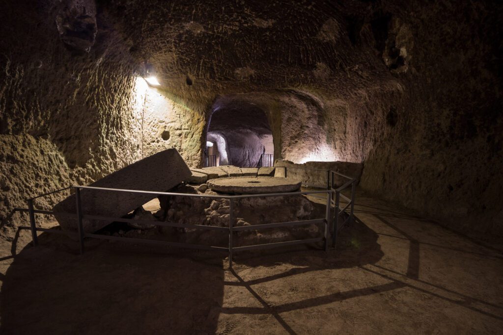 Mulino di Santa Chiara. Al centro di questo spazio dell’Orvieto Sotterranea si vede un frantoio in pietra.