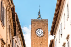 Vista dal basso della cima di Torre del Moro al centro, ai lati i tetti dei palazzi di Orvieto.