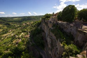 Vista dall'alto di un tratto del percorso dell'Anello della Rupe. Dalla Rocca Albornoz, guardando oltre ai muri che danno sullo strapiombo della Rupe, è possibile vedere un tratto del percorso di trekking che ad anello circumnaviga Orvieto. Sulla destra la rupe, che si tuffa verticalmente nel verde che ricomprendi tutta la parte sinistra dell'immagine.