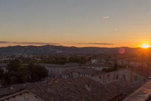 Vista del panorama visibile da Piazza Grande, con i quartieri medievali e le campagne umbre, al tramonto.