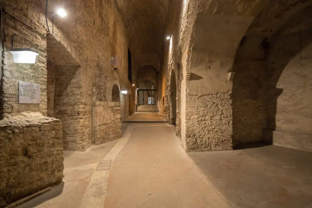 Vista di un corridoio percorribile all'interno della Rocca Paolina. Il corridoio è stretto, intervallato sulle pareti laterali da ampi archi da cui si diramano altre strade, e alto, coperto da una volta a botte.