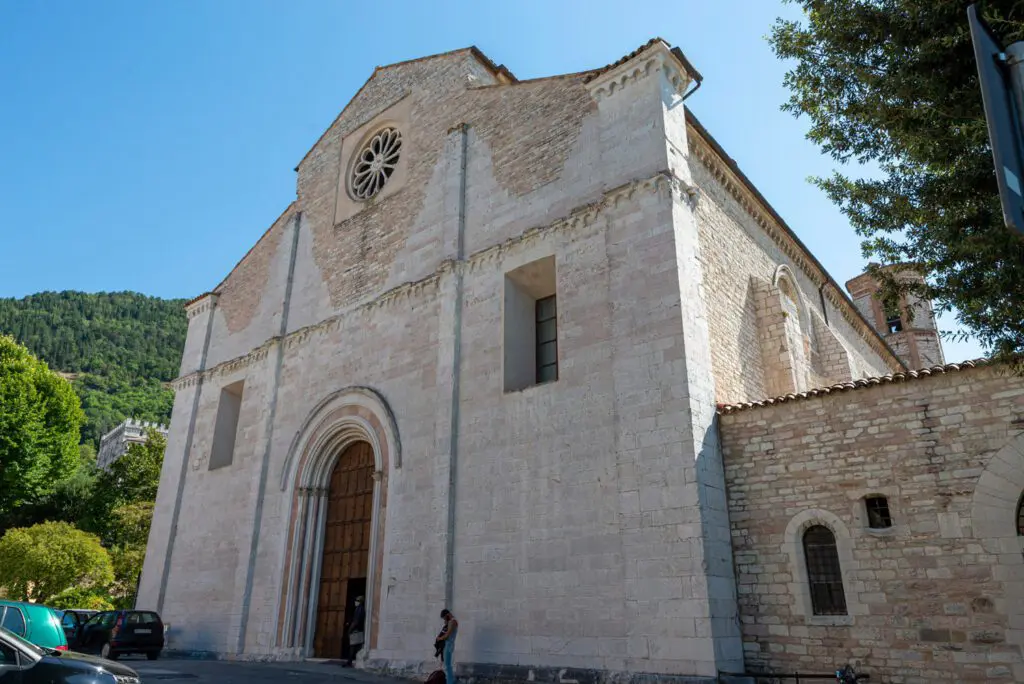 Vista scorciata della facciata romanica di San Francesco a Gubbio. Spiccano il grande portale di ingresso e il rosone.