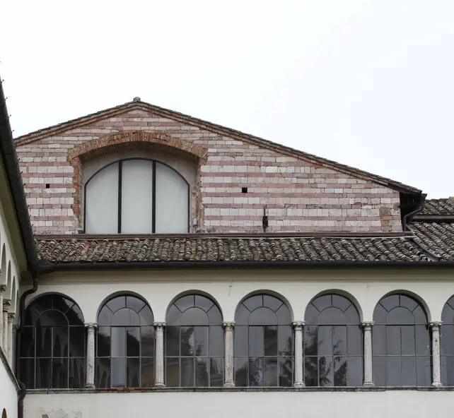 Vista frontale della facciata di San Domenico "vecchio". La facciata della chiesa originaria spunta di pochi metri al di sopra dei due livelli del chiostro, addossato alla facciata stessa.