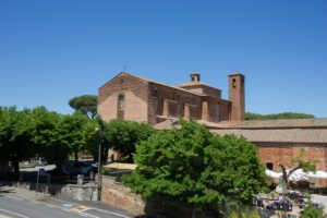 Vista in lontananza dell'imponente struttura della chiesa di San Francesco a Città della Pieve. Nel cielo azzurro si stagliano i rossi mattoni che compongono la struttura.