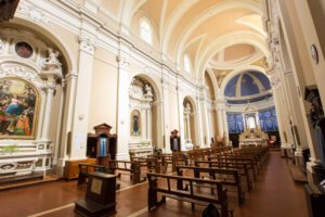 Vista dell'interno della chiesa di San Francesco a Città della Pieve. La chiesa, ad una sola navata, presenta diverse nicchie sulle mura laterali, nelle quali sono contente alcune opere. In fondo, l'abside dipinto di blu che risalta nella chiesa interamente dipinta in bianco e pesca.