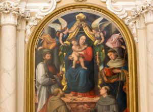 Vista frontale dell' opera che rappresenta la Madonna in trono che si trova in una delle nicchie nella navata della chiesa di San Francesco.