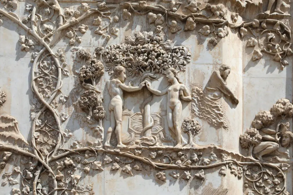 Dettaglio della decorazione scultorea in bassorilievo della facciata del Duomo. Al centro di tralci di vite sono raffigurati Adamo ed Eva nudi vicino all’albero del peccato sul quale è avvolto il serpente.