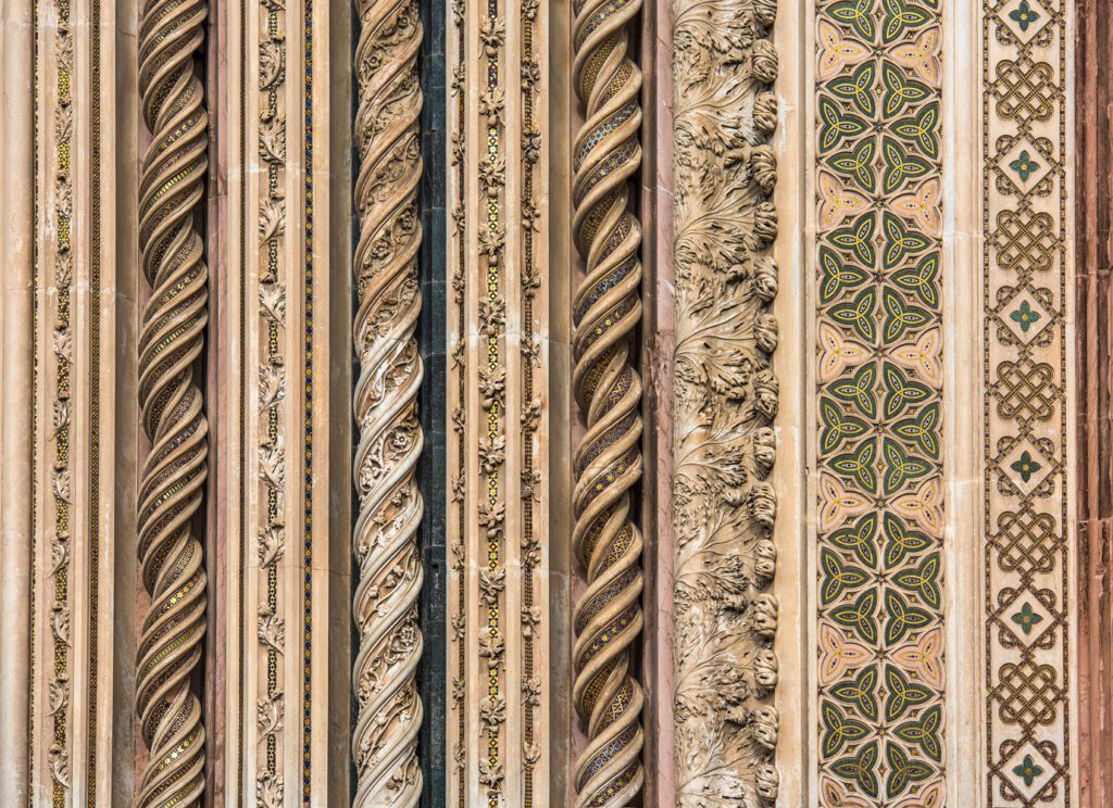 Dettaglio della decorazione del portale del Duomo. Colonne tortili in marmo rosa decorate con pasta vitrea e incisioni.